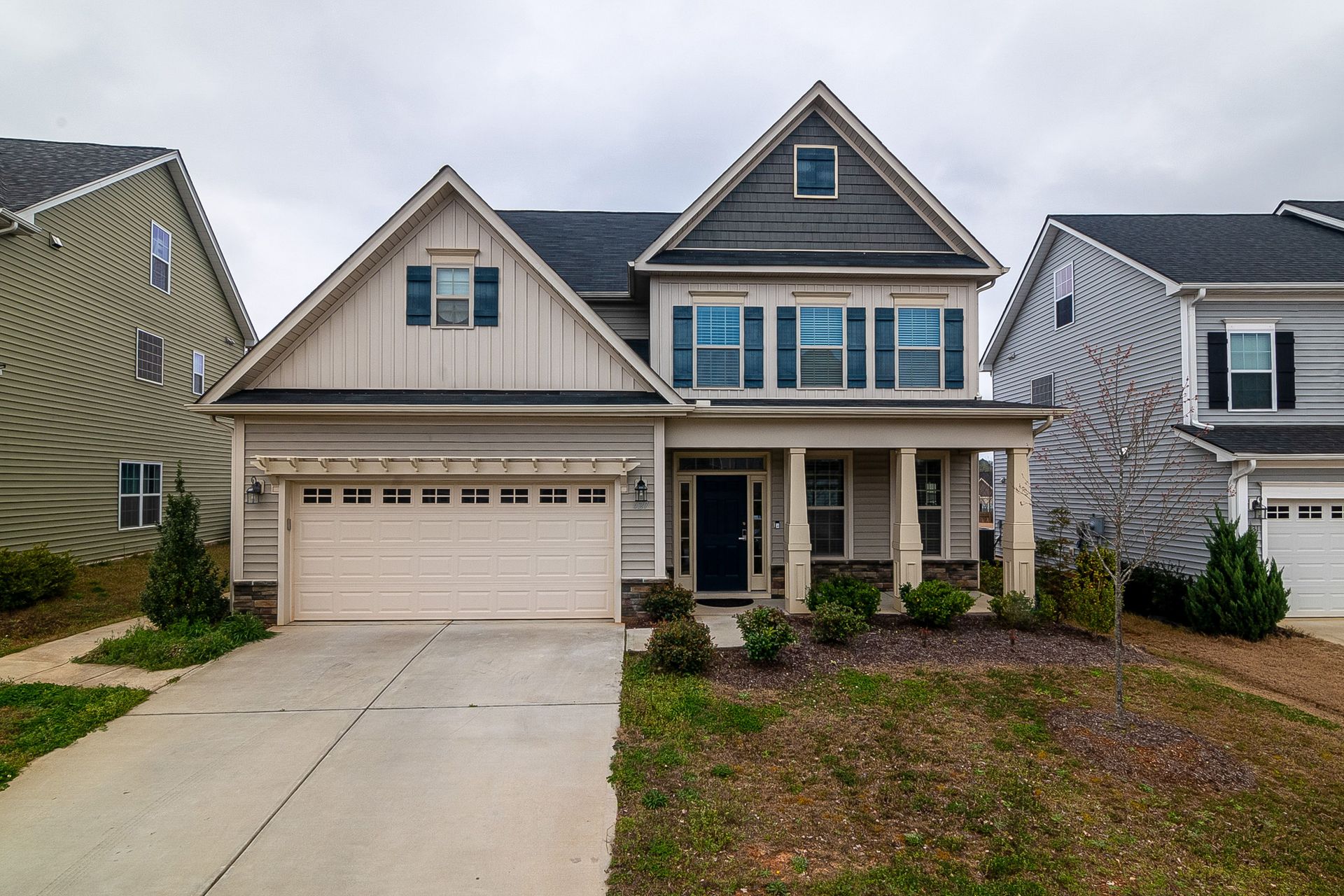 A modern two-story family home with a garage and landscaped yard in a suburban setting.